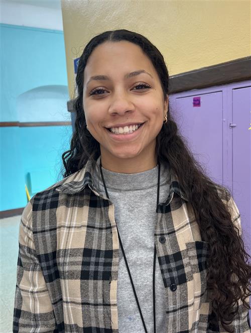 Teacher with plain blouse with gray blouse and she is smiling